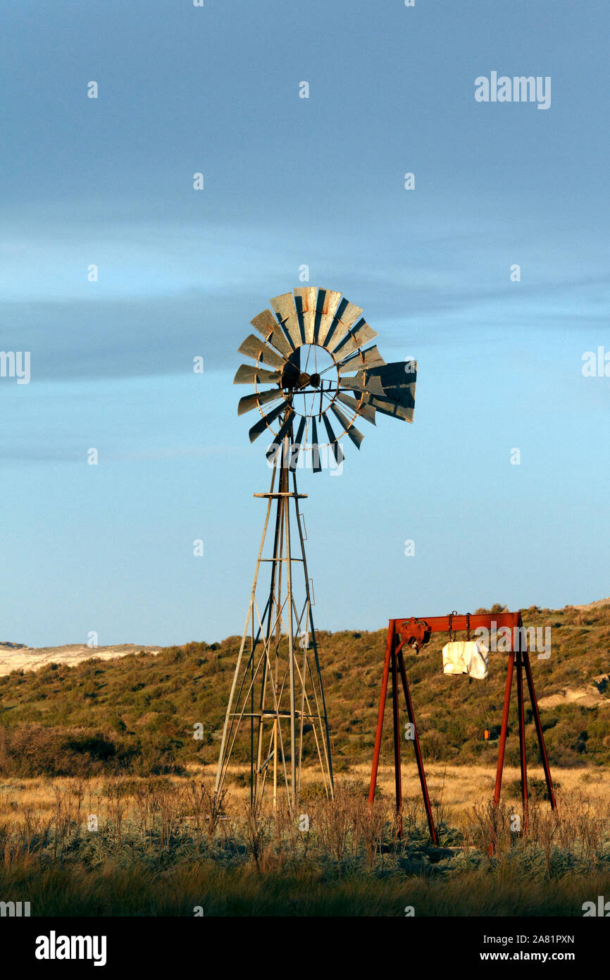 La pompa dell'acqua sulla terra arida in Patagonia. Approvvigionamento di acqua per un'azienda. Foto Stock