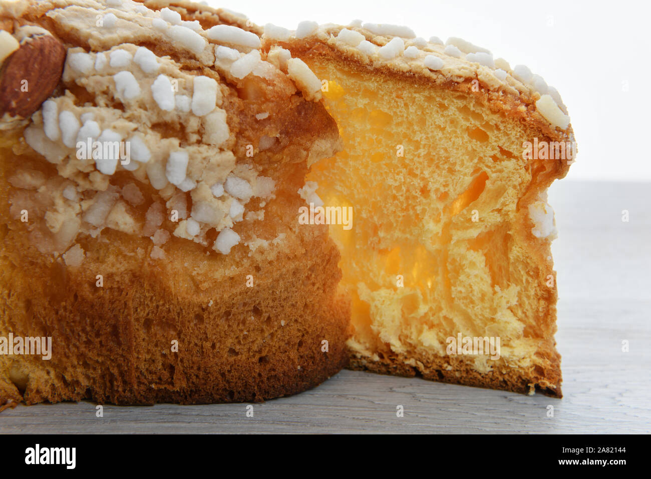 Italiano tradizionale torta di Pasqua. Colomba senza canditi e senza glassa di zucchero in smalto e con le mandorle. Tagliare il pezzo. Foto Stock
