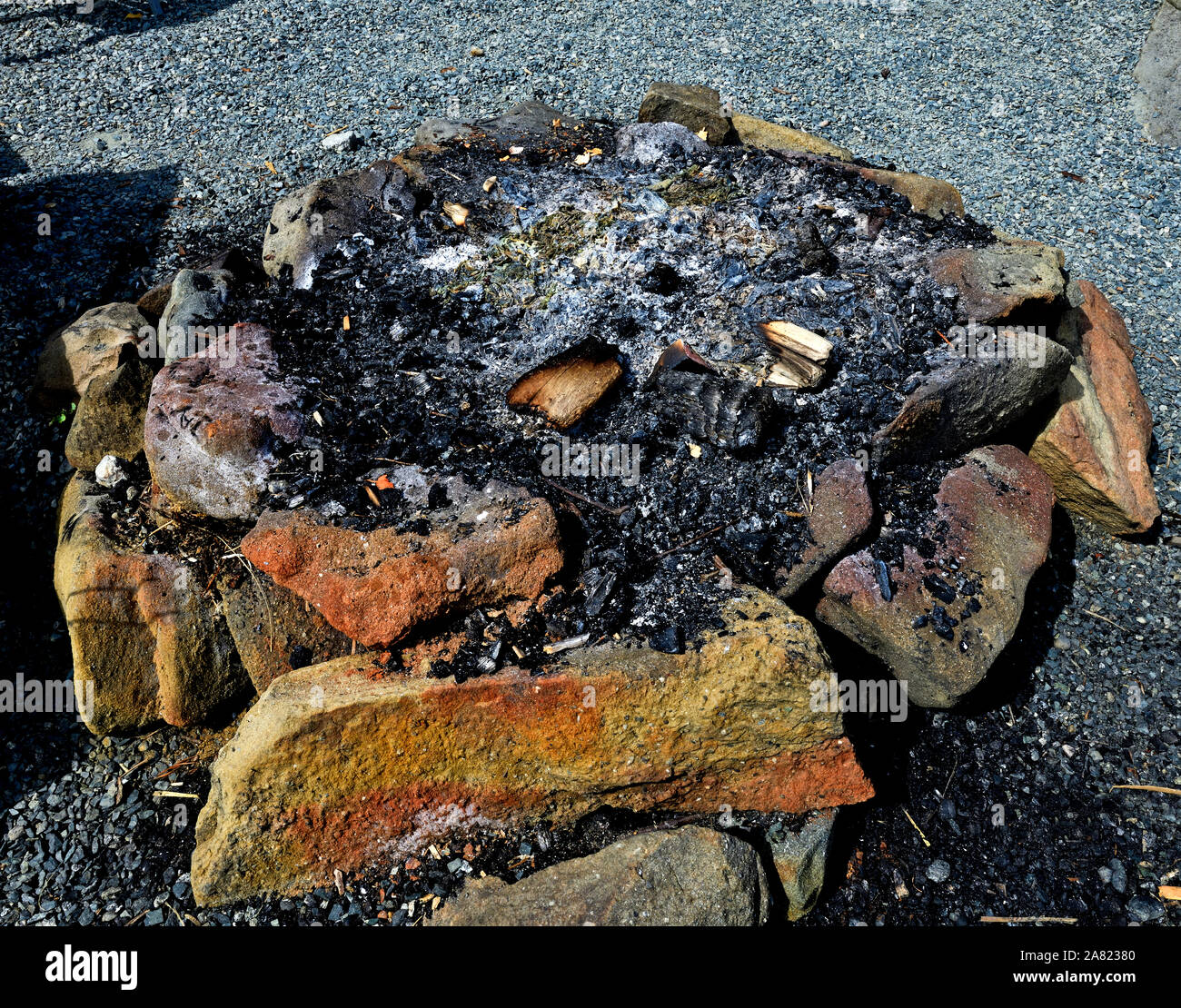 Un round in una buca per il fuoco realizzato dal posizionamento di pietre in un cerchio e utilizzata per bruciare il legno per la ricreazione e divertimento. Foto Stock