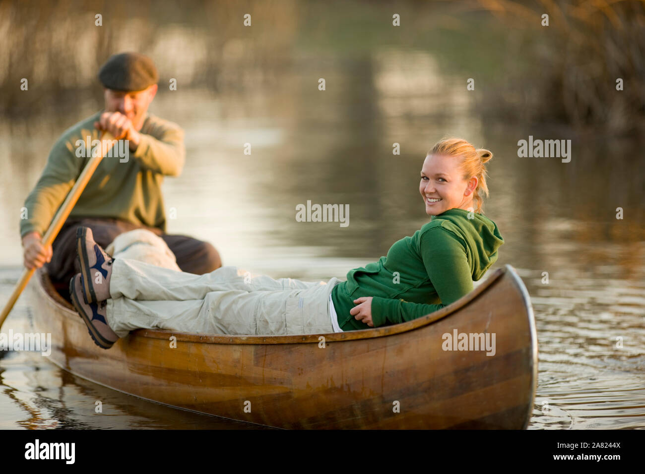 Ritratto di un sorridente giovane donna in una canoa con il suo fidanzato. Foto Stock