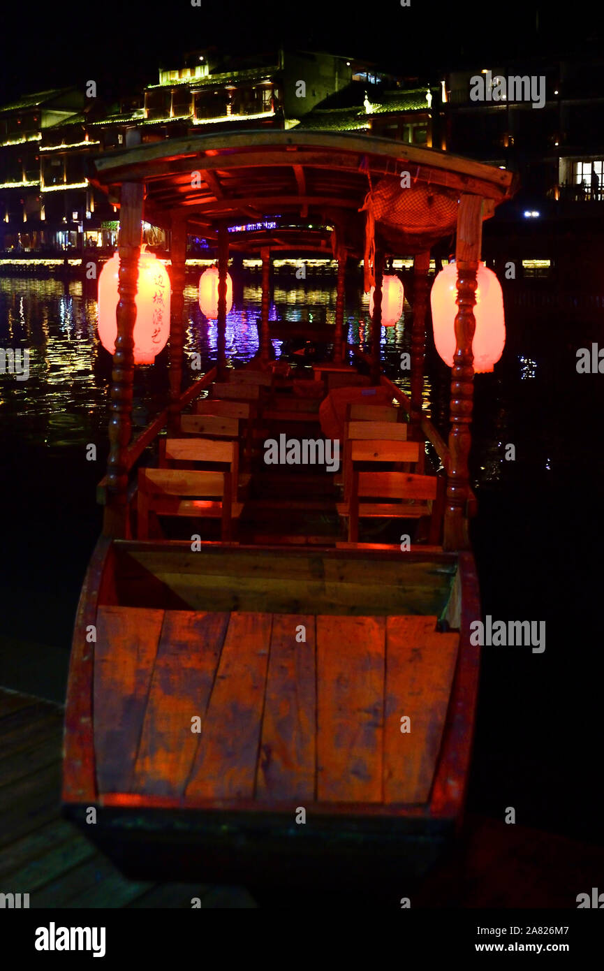 Un inserito tour in barca attende visite turistico a imbarcarsi sul tuo Jiang fiume di Fenghuang Città Antica, una attrazione preferita in Tibet, in Cina. Foto Stock