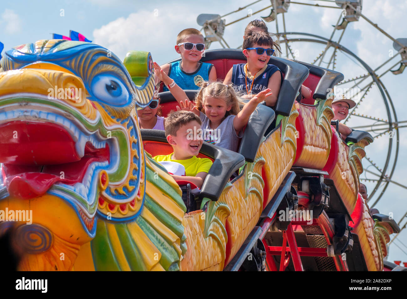 Battle Creek Michigan STATI UNITI D'AMERICA LUGLIO 4, 2019; bambini felici ridere come loro cavalcata su un roller coaster presso il campo volo di evento Foto Stock