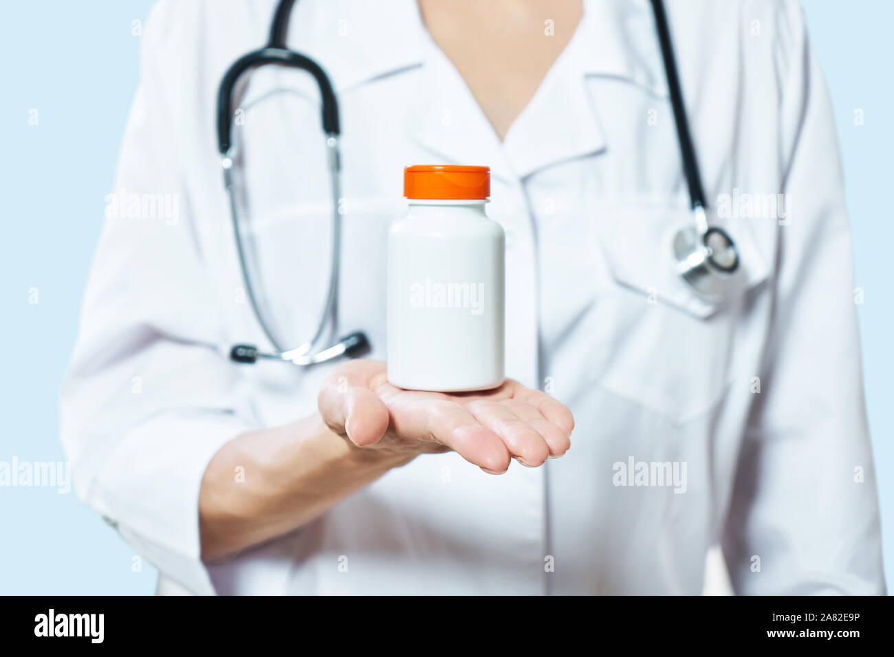Medico tenendo una bottiglia di pillole su sfondo bianco. Il concetto di medicina, farmacologia, healthcare Foto Stock