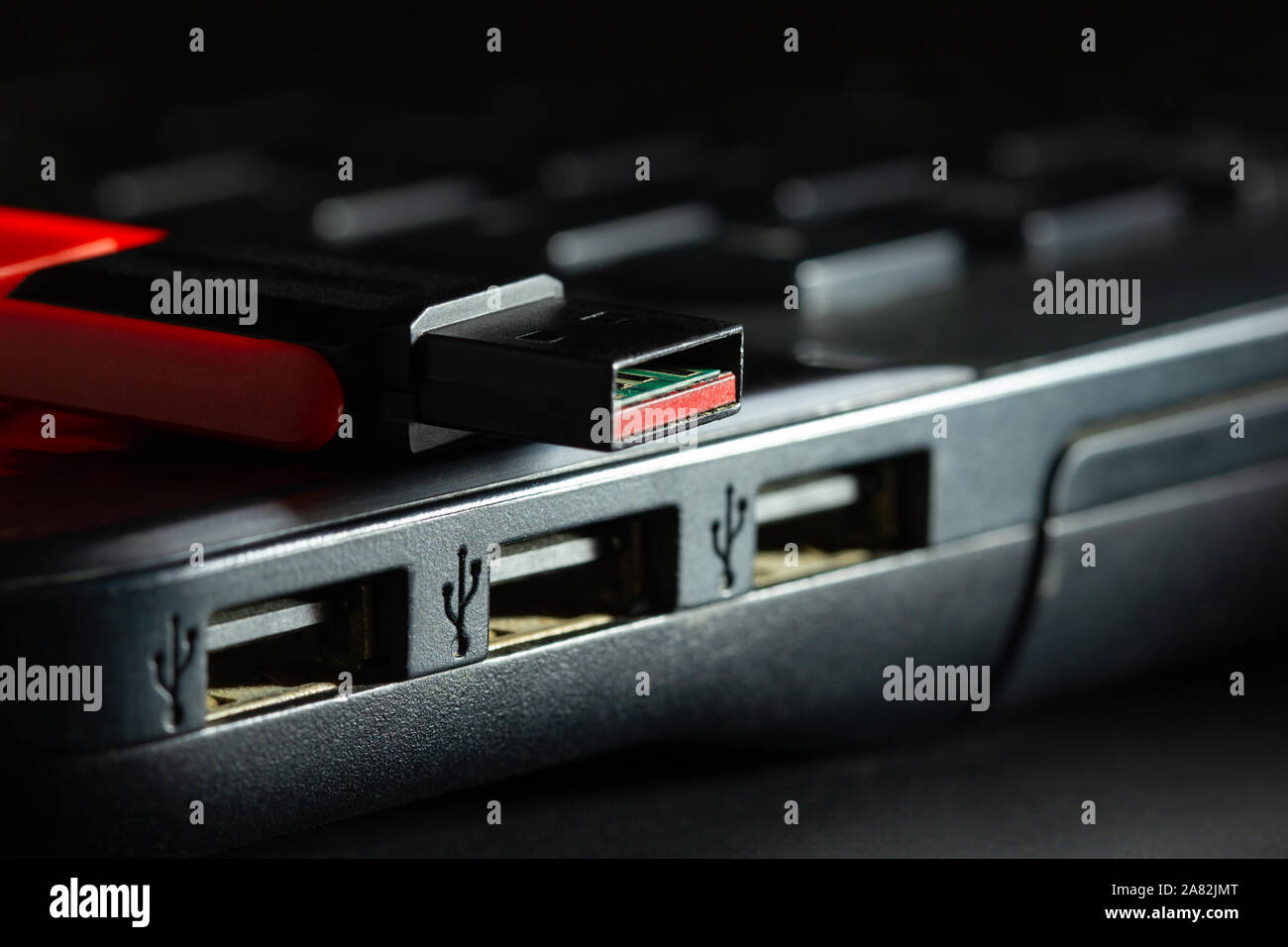 Unità flash nella porta USB del computer notebook in tenebre. Concetto di progresso tecnologico nel computer i dati dei sistemi di registrazione. Foto Stock