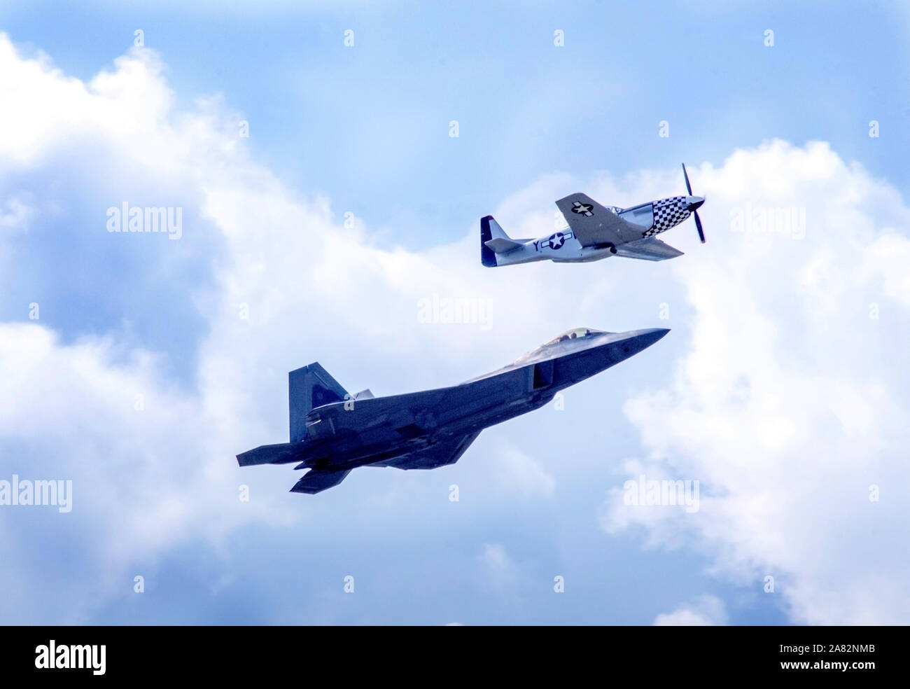 Battle Creek Michigan STATI UNITI D'AMERICA LUGLIO 4, 2019; un p 51 mustang vola lungo una F 22 Raptor Fighter jet, durante il campo di volo air show Foto Stock