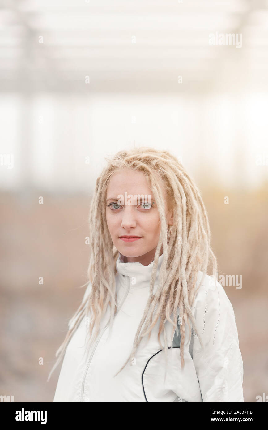Giovane donna in abiti bianchi con dreadlocks ritratto di acconciatura Foto Stock