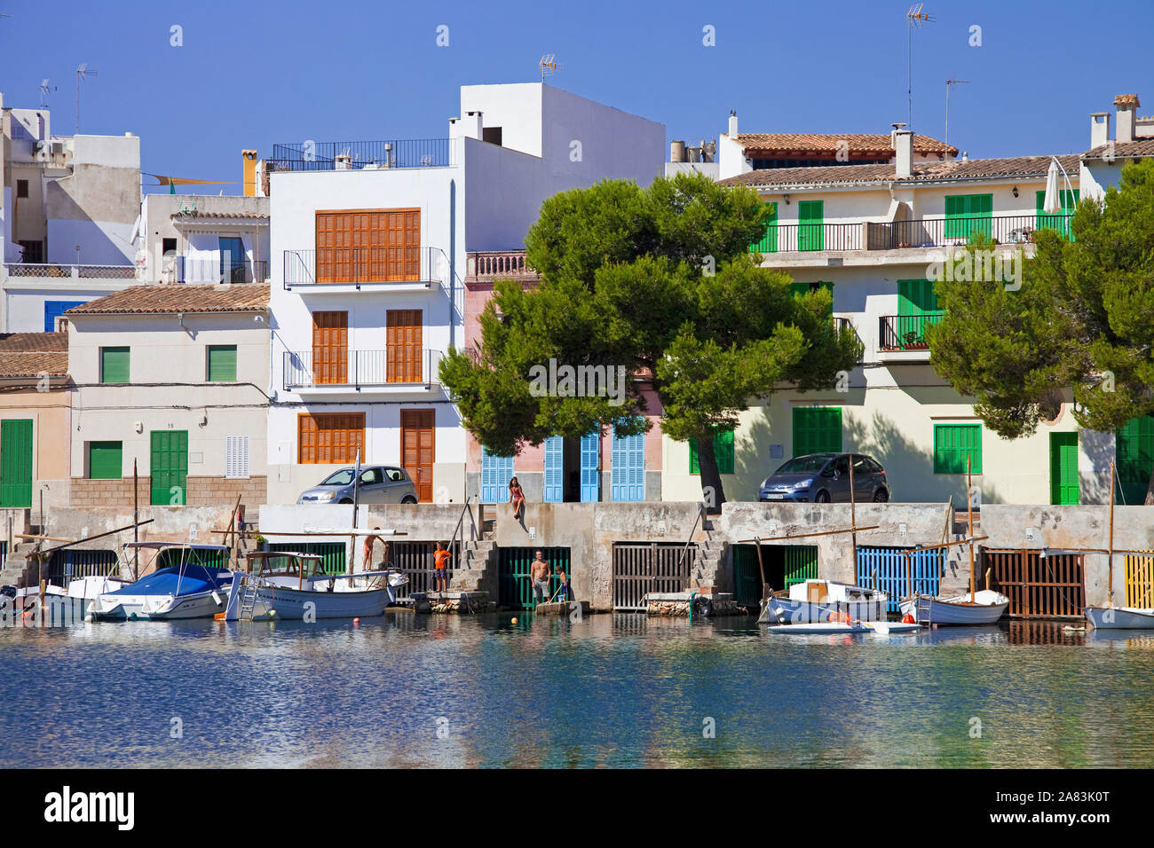 Garage in barca sotto ex case di pesca e storico porto di Porto Colom, Maiorca, isole Baleari, Spagna Foto Stock