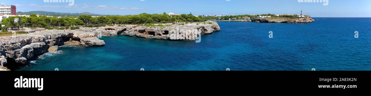 Faro e costa rocciosa a Porto Colom, Maiorca, isole Baleari, Spagna Foto Stock
