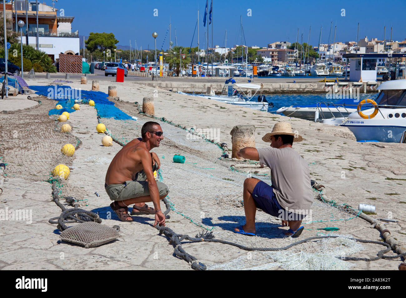 I pescatori a riparare le reti presso il porto di Porto Colom, Maiorca, isole Baleari, Spagna Foto Stock