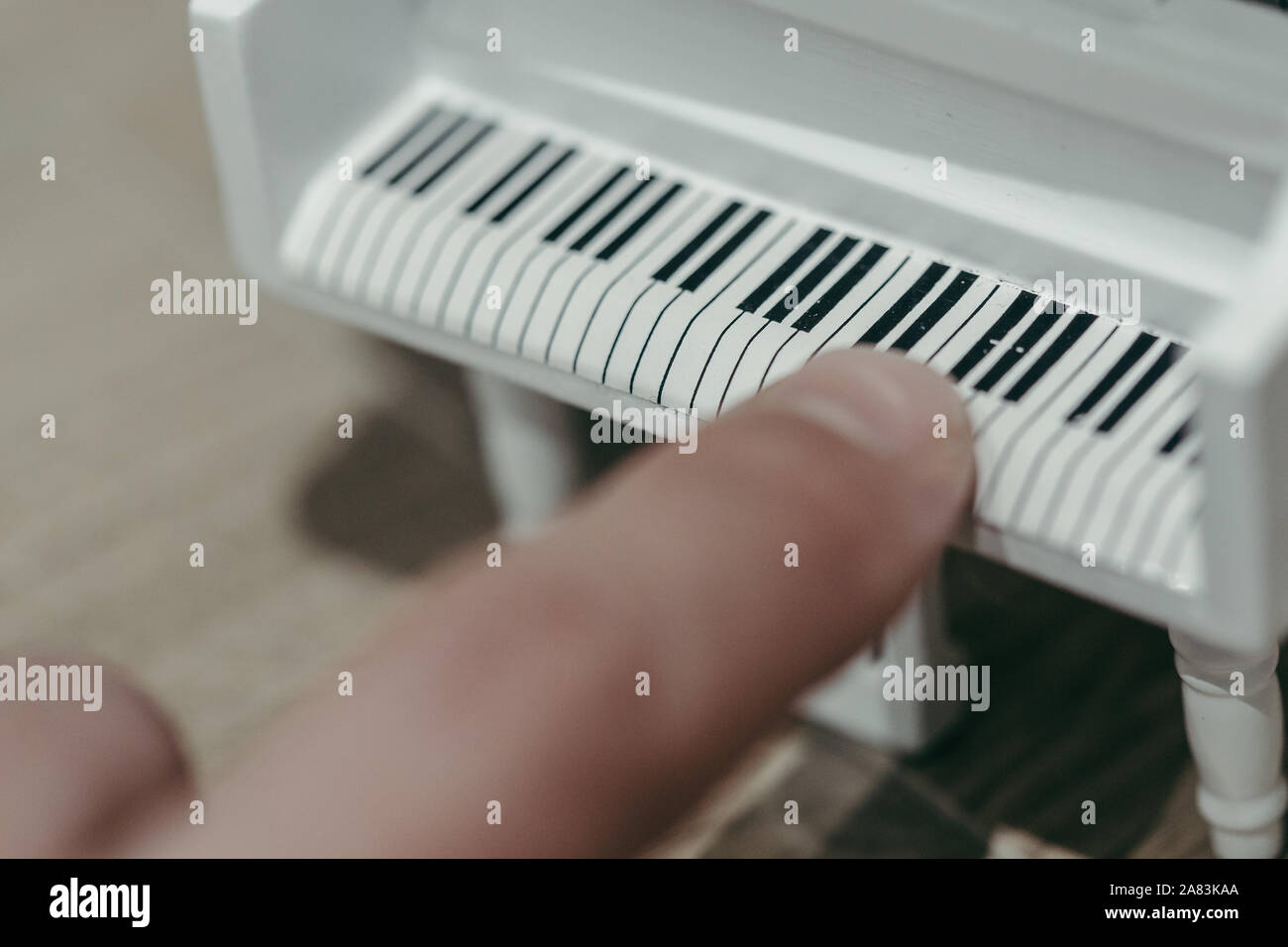 Giocare con un dito una piccola tastiera giocattolo pianoforte Foto Stock