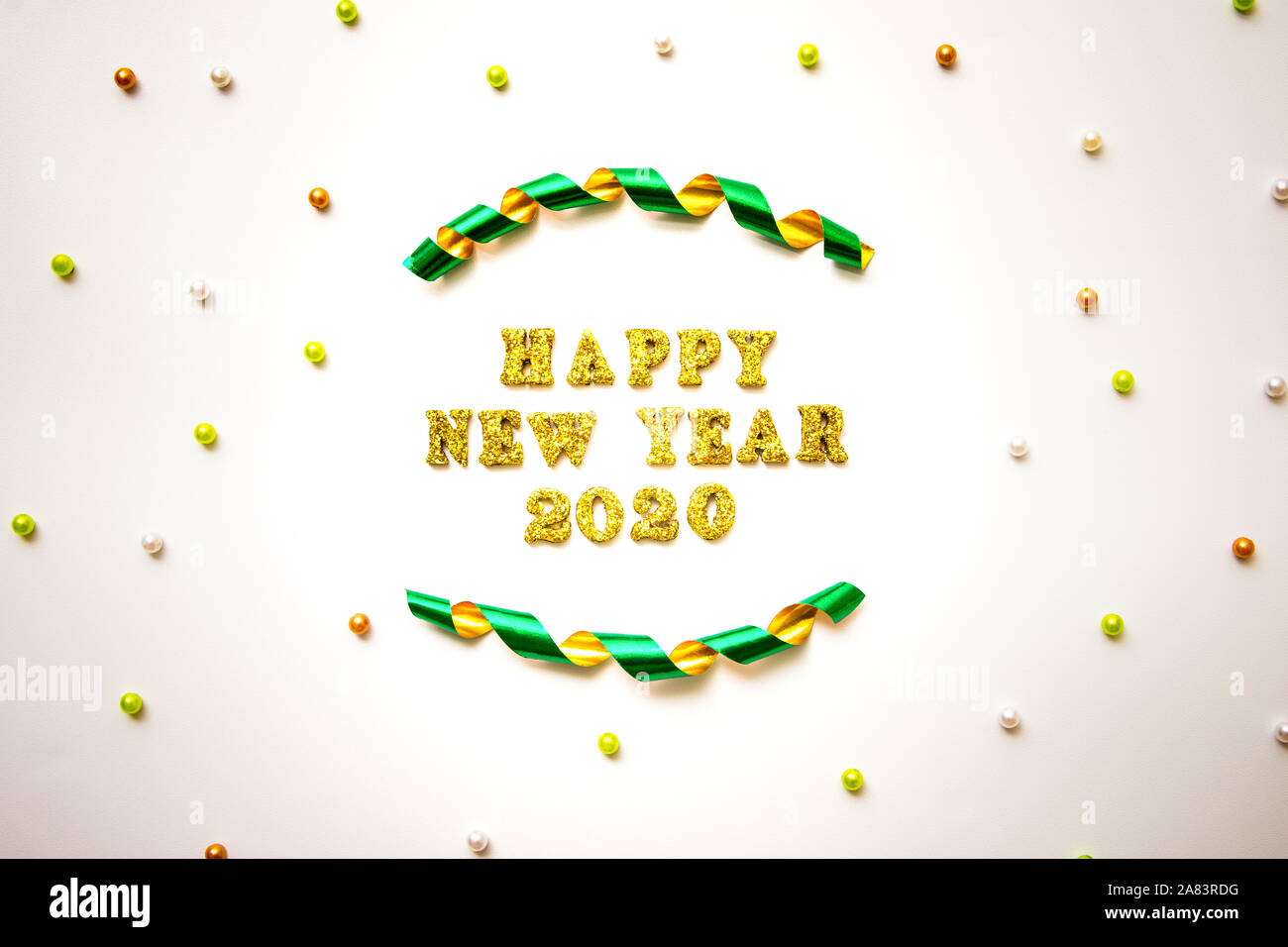 Semplice felice anno nuovo 2020 Testo in oro scritte, Nastro arricciato e perline colorate isolati su sfondo bianco - Celebrazione e concetto di vacanze Foto Stock