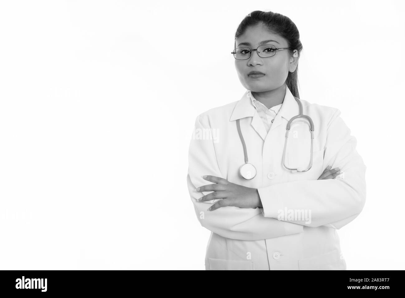 Studio shot di giovani grasso donna persiano medico con le braccia incrociate Foto Stock