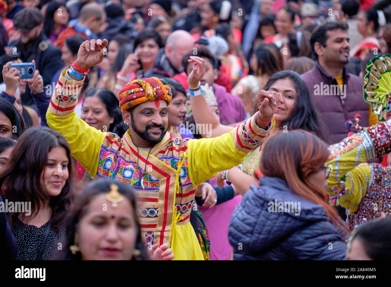 Abbigliamento tradizionale maschio indiano ballerini danzare nel mezzo della folla festante durante il Diwali celebrazioni a Londra, UK, 3 novembre 2019 Foto Stock