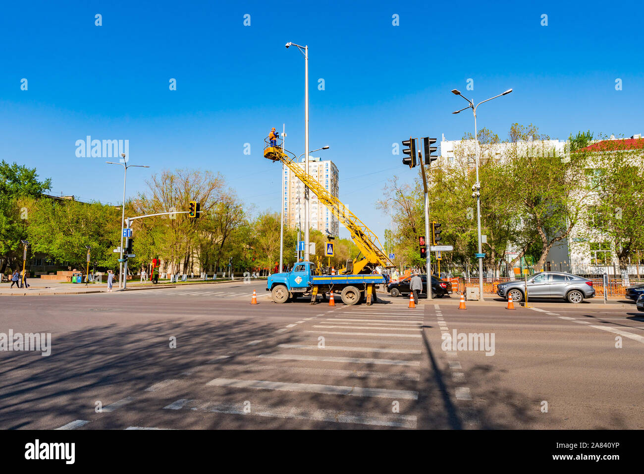 Nur-Sultan Astana Roadworks lavoratori sono il fissaggio della strada le telecamere di sorveglianza su un soleggiato Blue Sky giorno Foto Stock