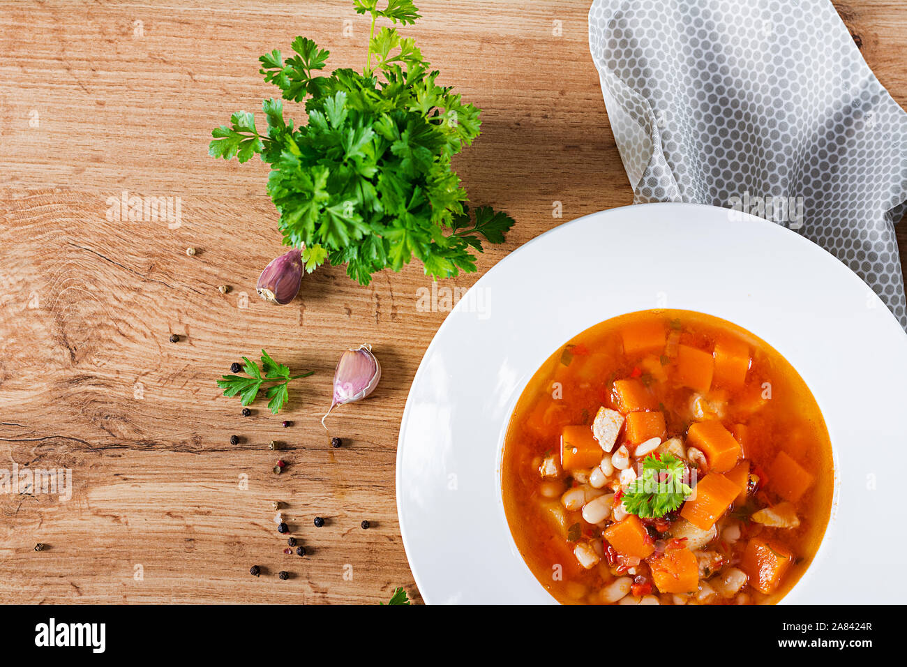 Pollo al pomodoro con zuppa di zucca e fagioli bianchi in bianco ciotola. Vista superiore Foto Stock