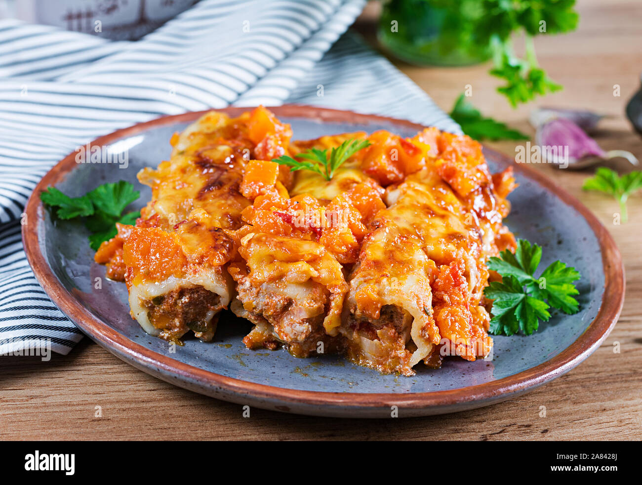 Cannelloni di carne di zucca con salsa di pomodoro sulla piastra. Foto Stock