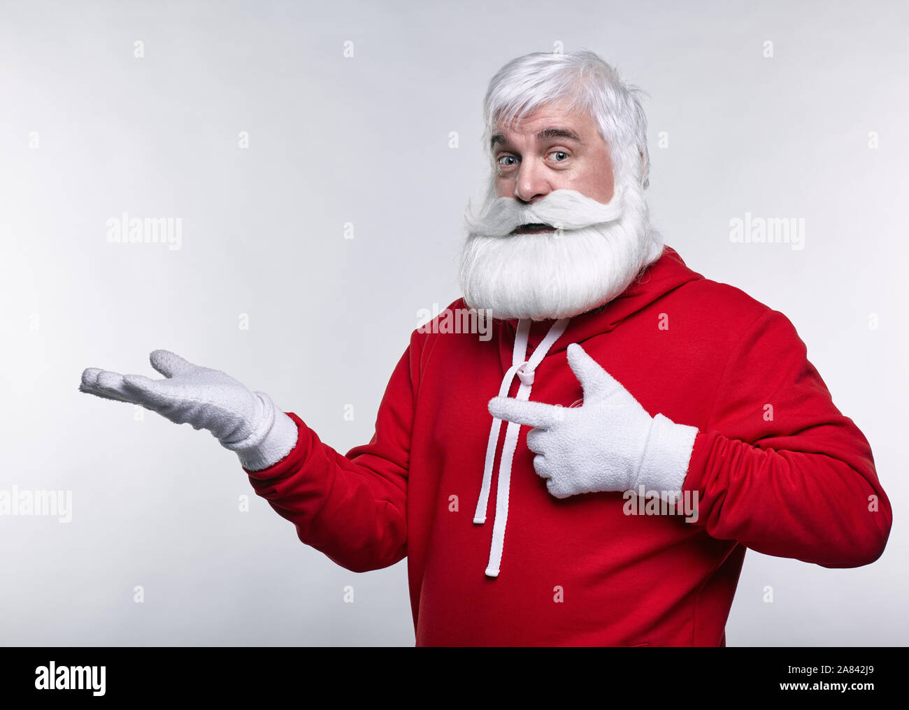 Ritratto di una Santa Claus in sportsware. Bianco-dai capelli uomo anziano con barba e baffi cercando nella fotocamera. Foto Stock