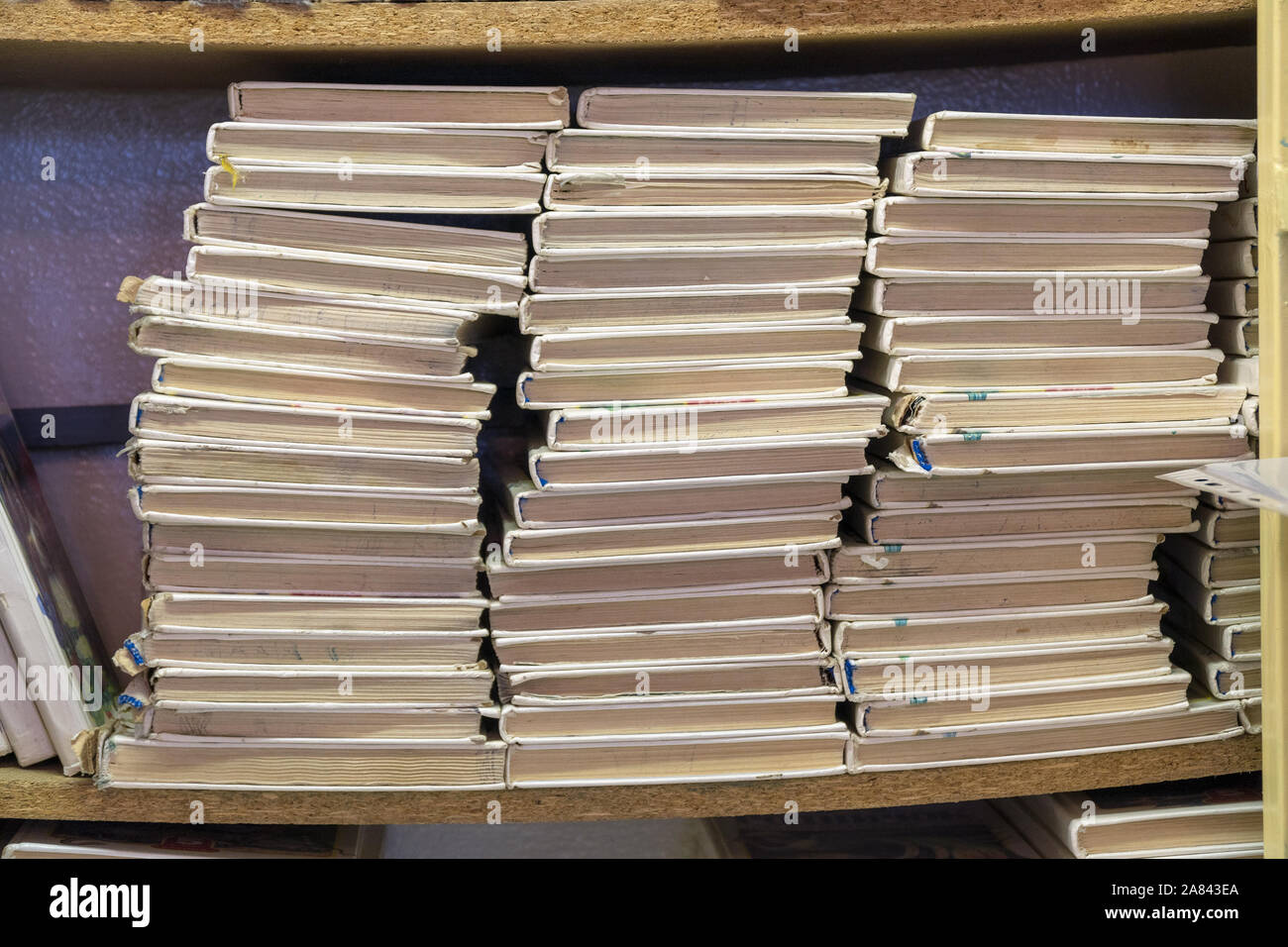 Vecchi Libri impilati in pile sul ripiano. Rifiuti di carta Foto Stock