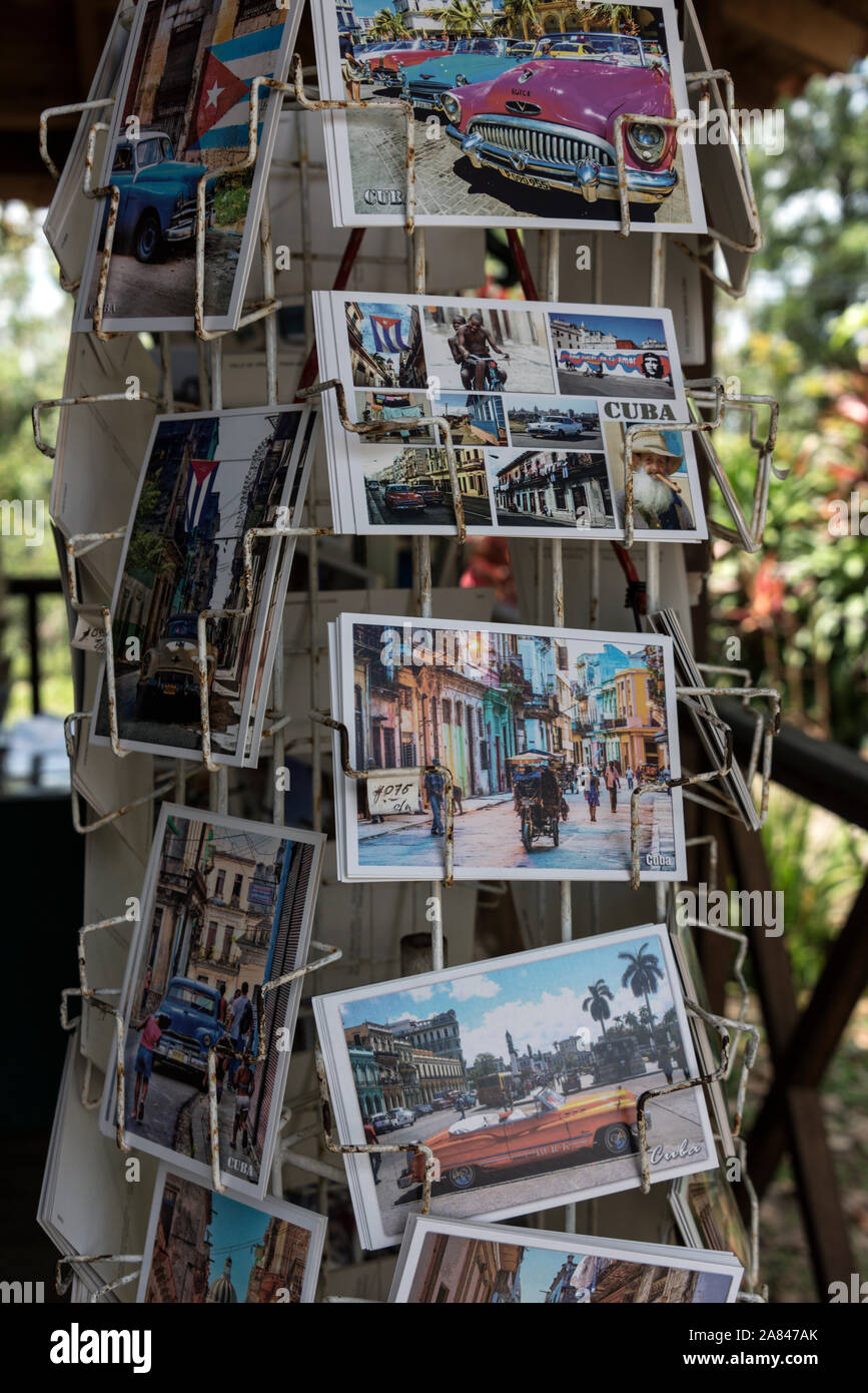 Un rack di cartoline turistiche di La Habana e la sua auto classiche in vendita su un souvenir turistici stallo in Cuba Foto Stock