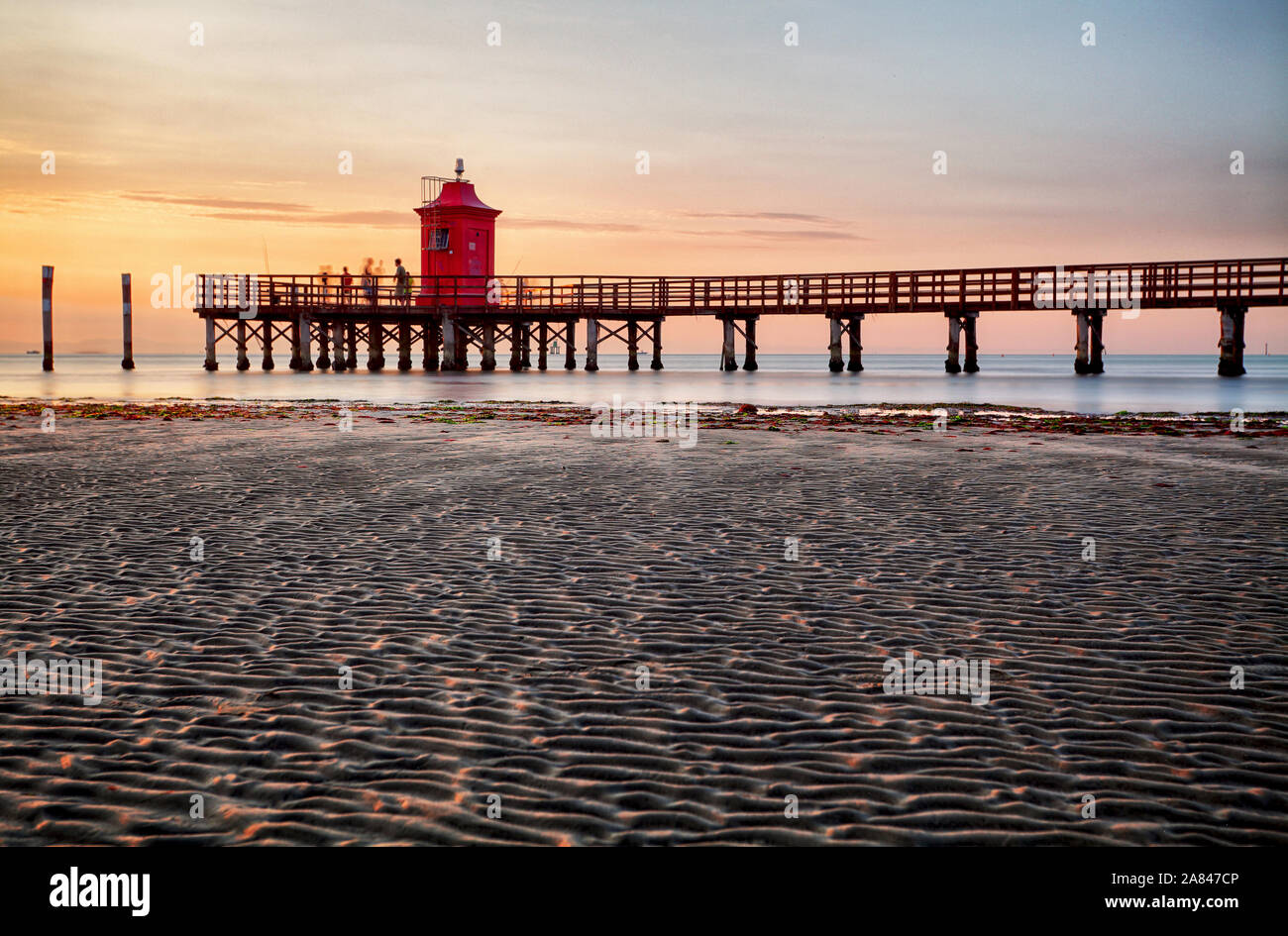 Faro al tramonto in Italia con la spiaggia Foto Stock