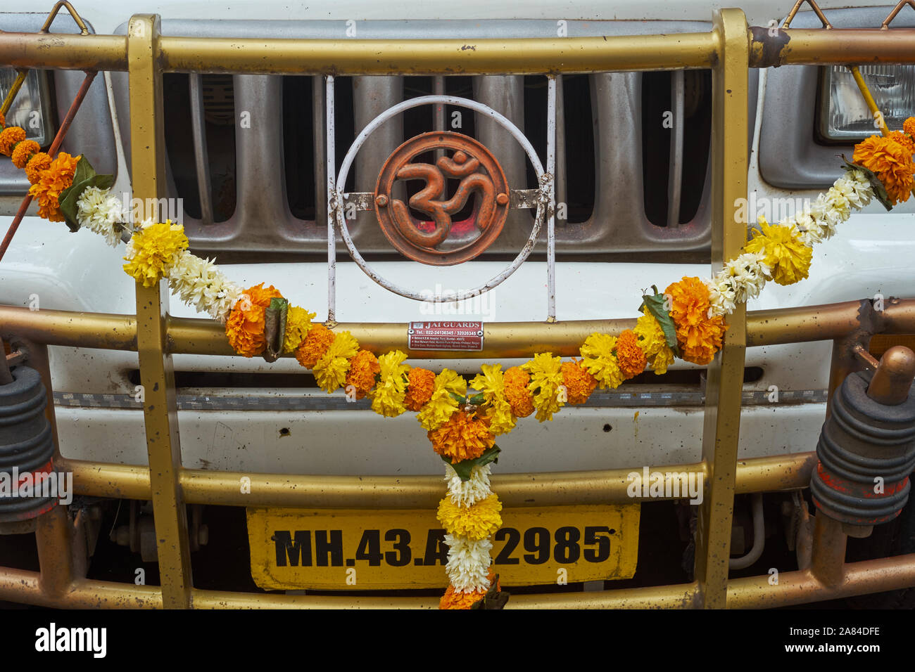 Un carrello in India decorata con un sacro ॐ (AUM OM) simbolo e una ghirlanda di fiori di tagete, per buona fortuna e senza incidenti viaggi Foto Stock