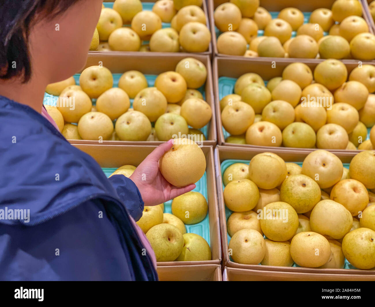 Asian capelli corti donna picking mentre acquistare fresca pera coreana Foto Stock
