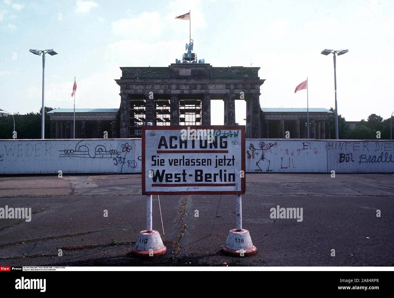 Una vista del "muro di Berlino e Porta di Brandeburgo, simbolo della città di Berl. Un segno bordo in tedesco avvisa "Stai lasciando Berlino Ovest". Il muro di Berlino era stato eretto in Agosto 13, 1961 da la RDT (Repubblica Democratica Tedesca) al reparto di imperialismo occidentale e ostacolare tedeschi orientali da rivelare all'Occidente. Berlino ovest, Germania ovest - 08/1986 (HALEY / SIPA/IPA / Fotogramma, BERLINO OVEST - 2014-10-17) ps la foto può essere utilizzato nel rispetto del contesto in cui è stato preso e senza intento diffamatorio del decoro delle persone rappresentate editoriale solo di utilizzo Foto Stock
