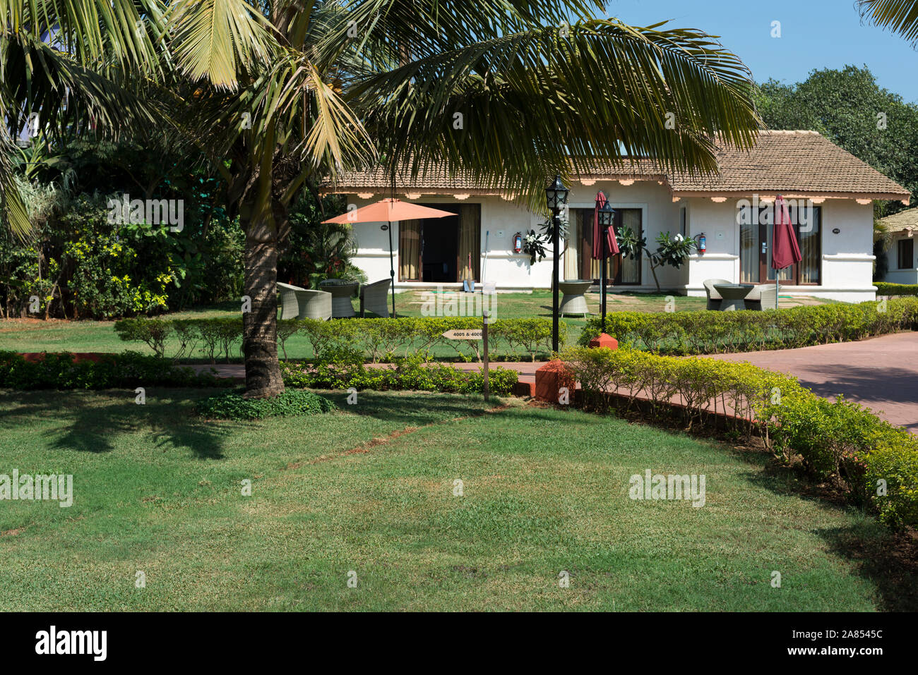 Giardino e camere cottage vista dal ristorante bar di lusso esclusivo resort sulla spiaggia. La Calypso, Baga Beach, Goa, India Foto Stock