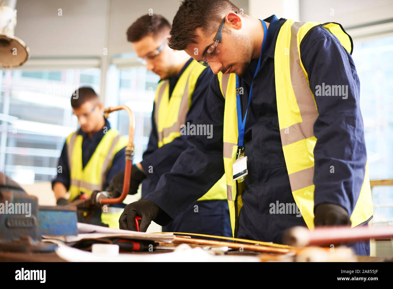 Concentrati gli studenti di sesso maschile in negozio officina di classe Foto Stock