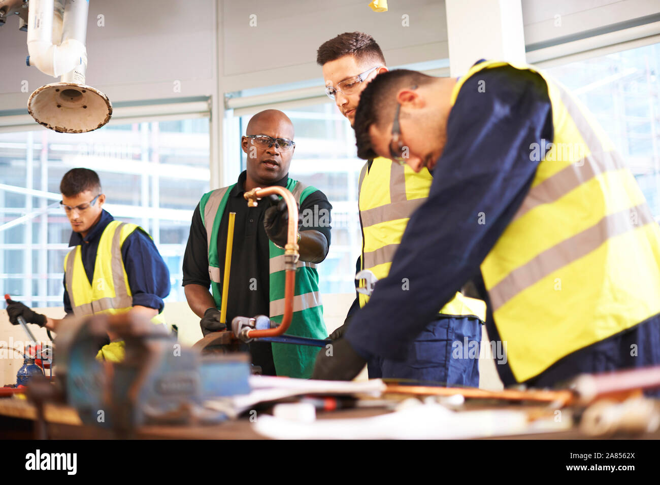 Istruttore maschio e gli studenti in classe officina officina Foto Stock
