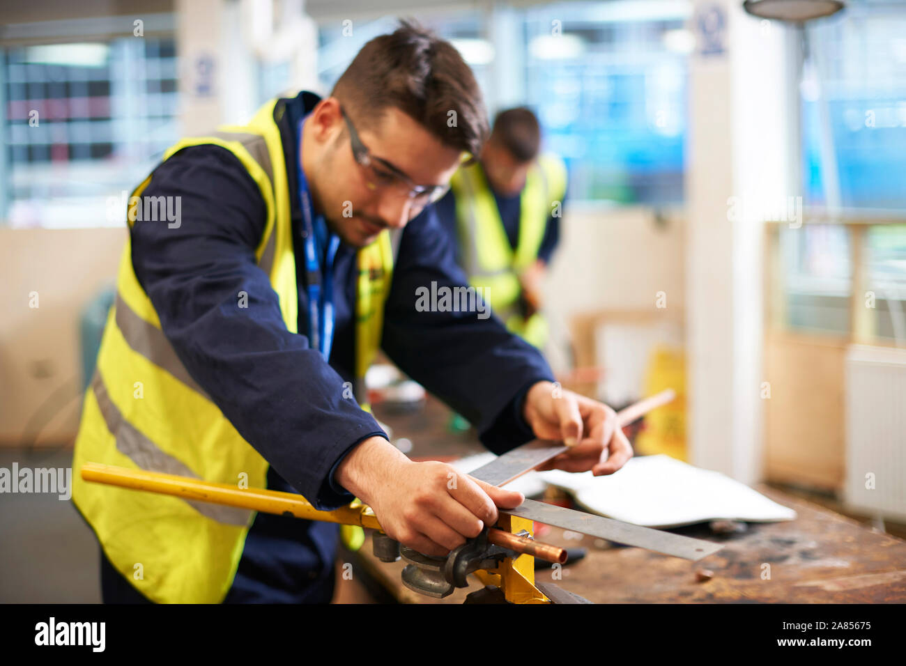 Studente maschio utilizzando carpenter regola in negozio officina di classe Foto Stock