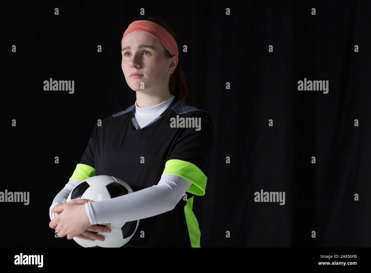 Ritratto fiduciosi, ambiziosa ragazza adolescente soccer giocatore in possesso palla Foto Stock