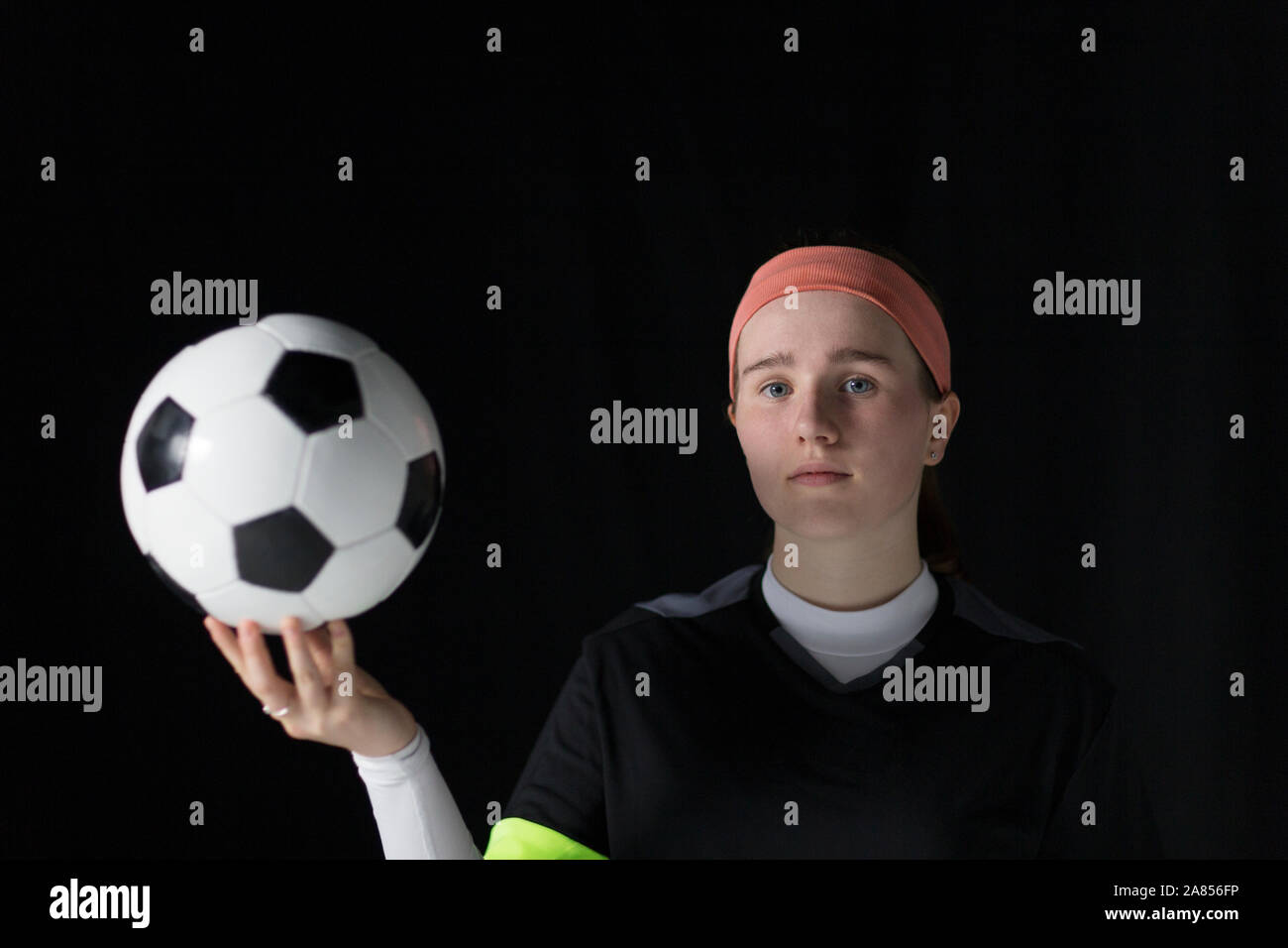 Ritratto fiduciosi, determinata ragazza adolescente soccer giocatore in possesso palla calcio Foto Stock
