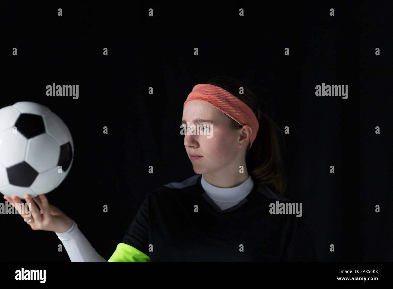 Focalizzato ragazza adolescente soccer giocatore in possesso palla Foto Stock