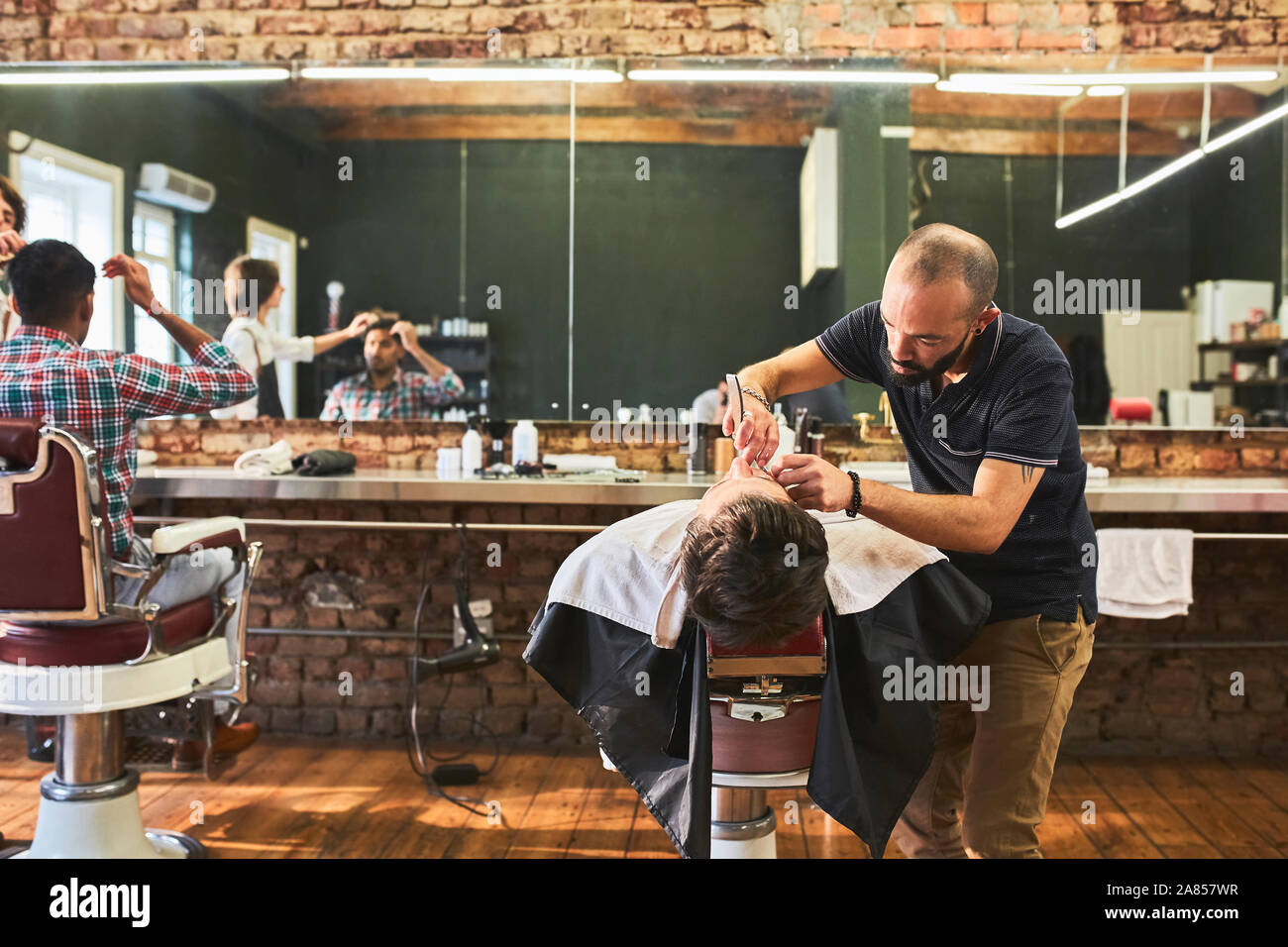 Maschio di rasatura barbiere faccia del cliente in Barberia Foto Stock