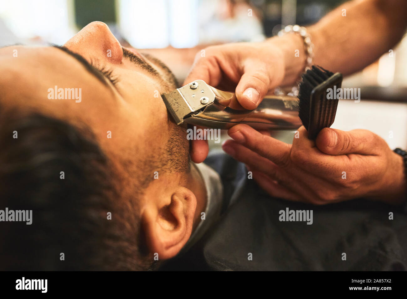 Chiudere l'uomo riceve una rasatura in Barberia Foto Stock