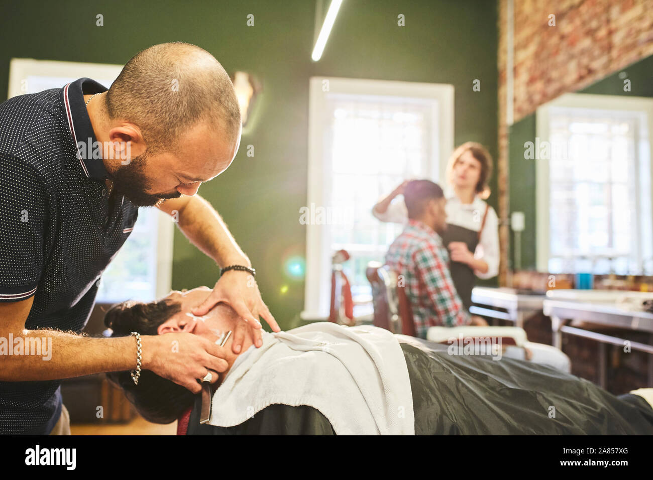 Maschio di rasatura barbiere faccia del cliente in Barberia Foto Stock