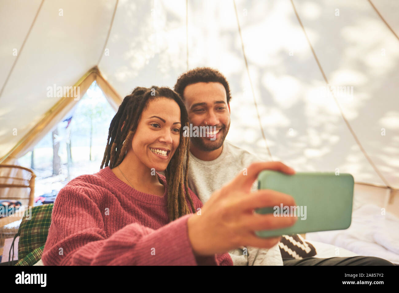 Coppia felice tenendo selfie in camping yurt Foto Stock
