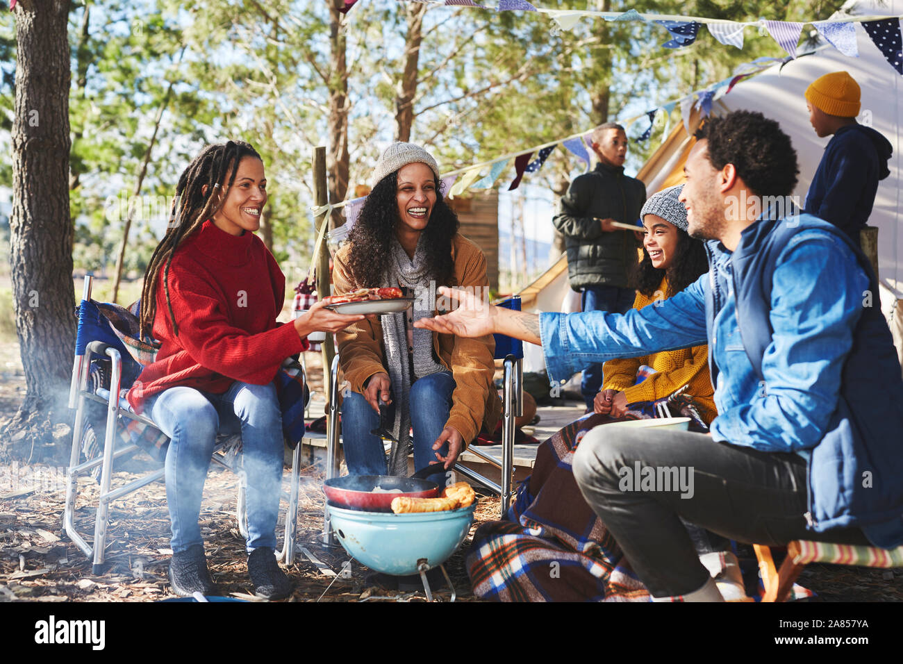 La famiglia felice di mangiare al campeggio di sole Foto Stock