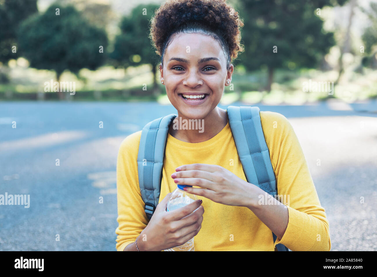 Ritratto felice, fiducioso giovane donna con una bottiglia d'acqua Foto Stock