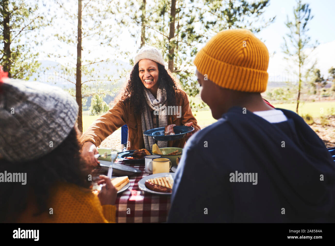 Felice madre e bambini per mangiare in campeggio Foto Stock