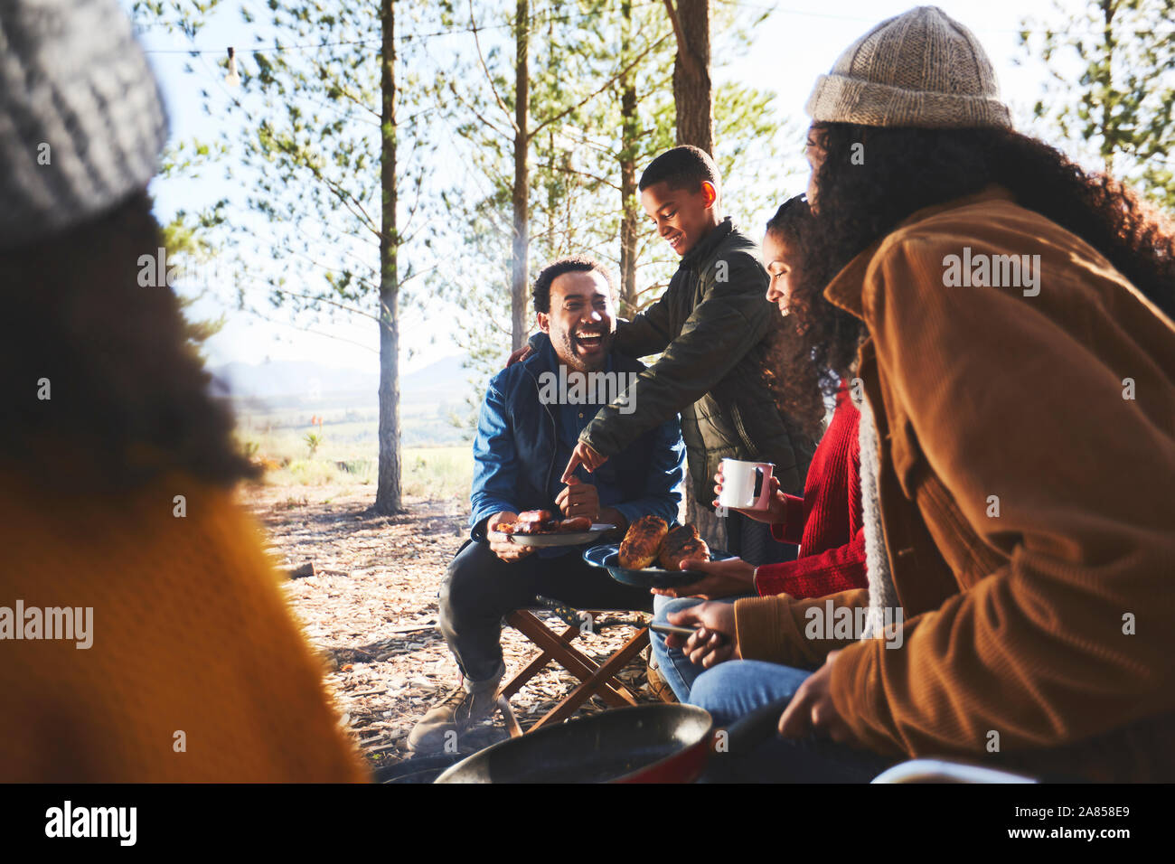 La famiglia felice di mangiare al campeggio di sole Foto Stock