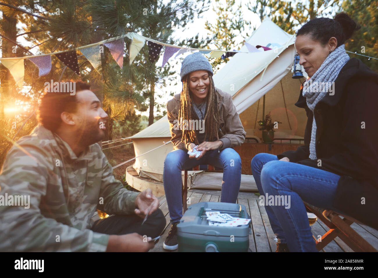 Gli amici a giocare a carte in campeggio Foto Stock