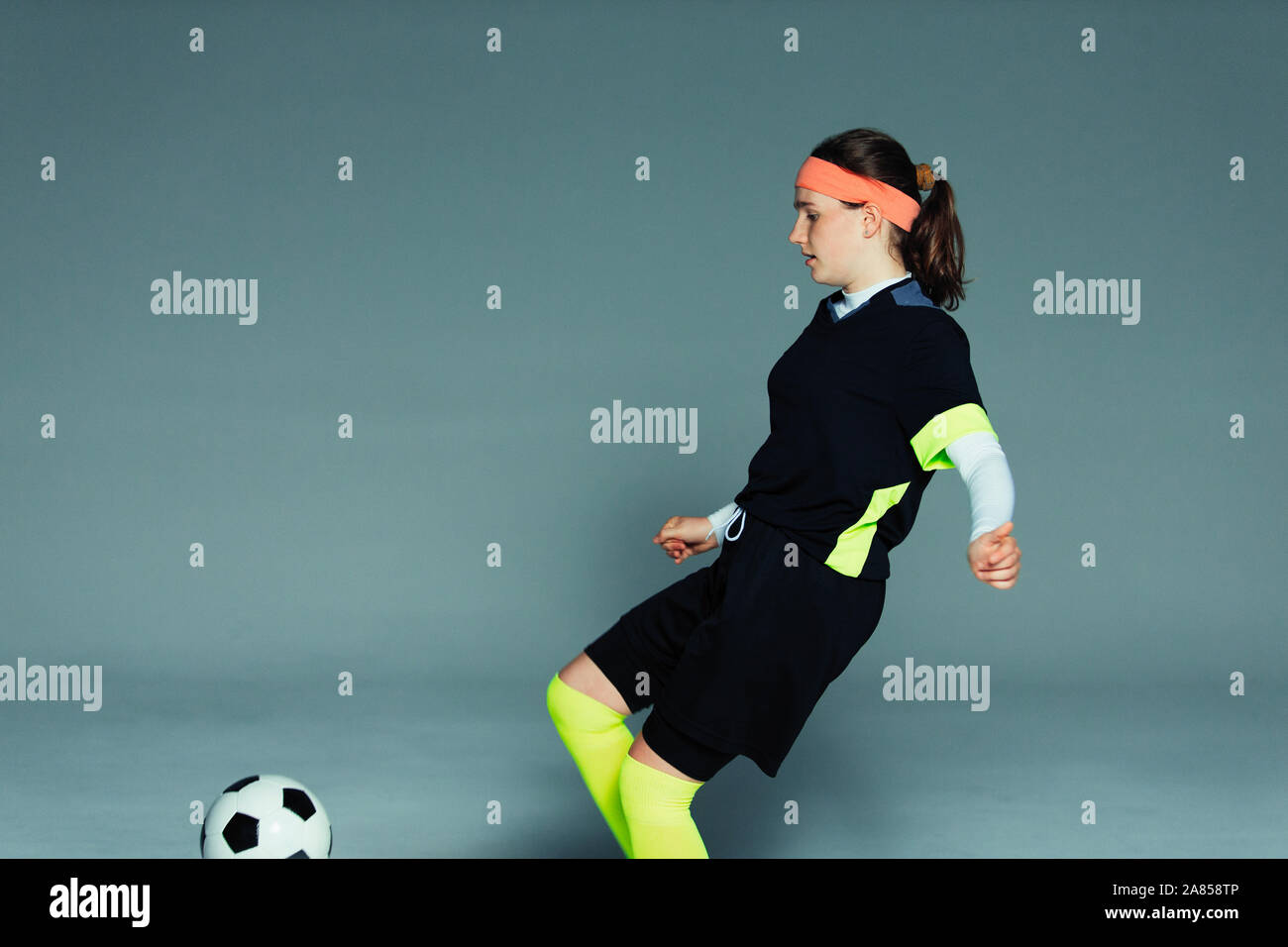 Ragazza adolescente giocatore di calcio calci palla calcio Foto Stock