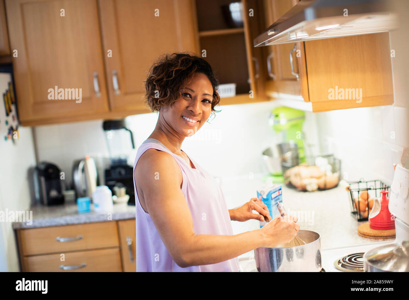 Ritratto sorridente, fiducioso donna la cottura in cucina Foto Stock