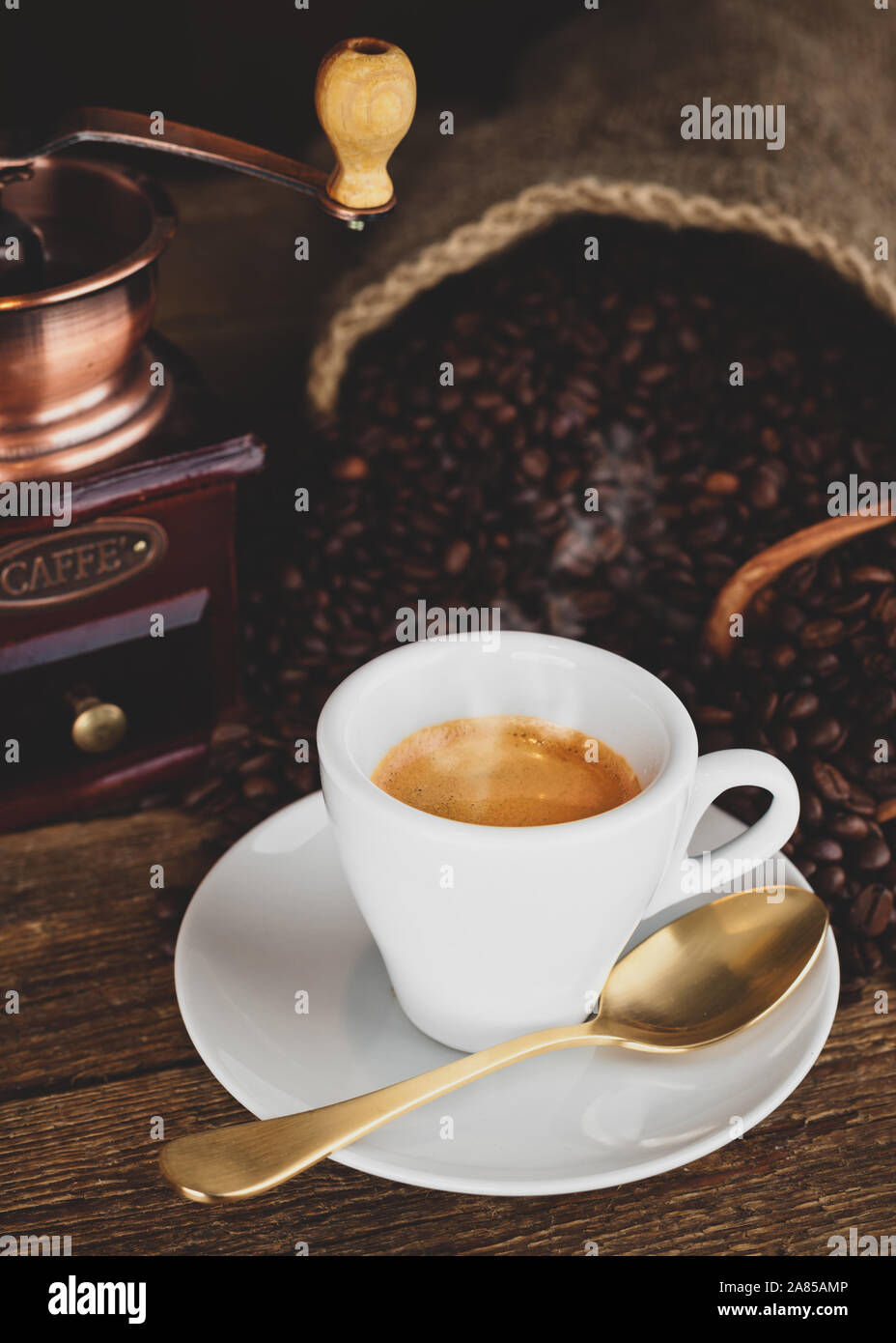 Tazza di caffè espresso, i chicchi di caffè e vecchio macinino da caffè sul tavolo di legno. Foto Stock