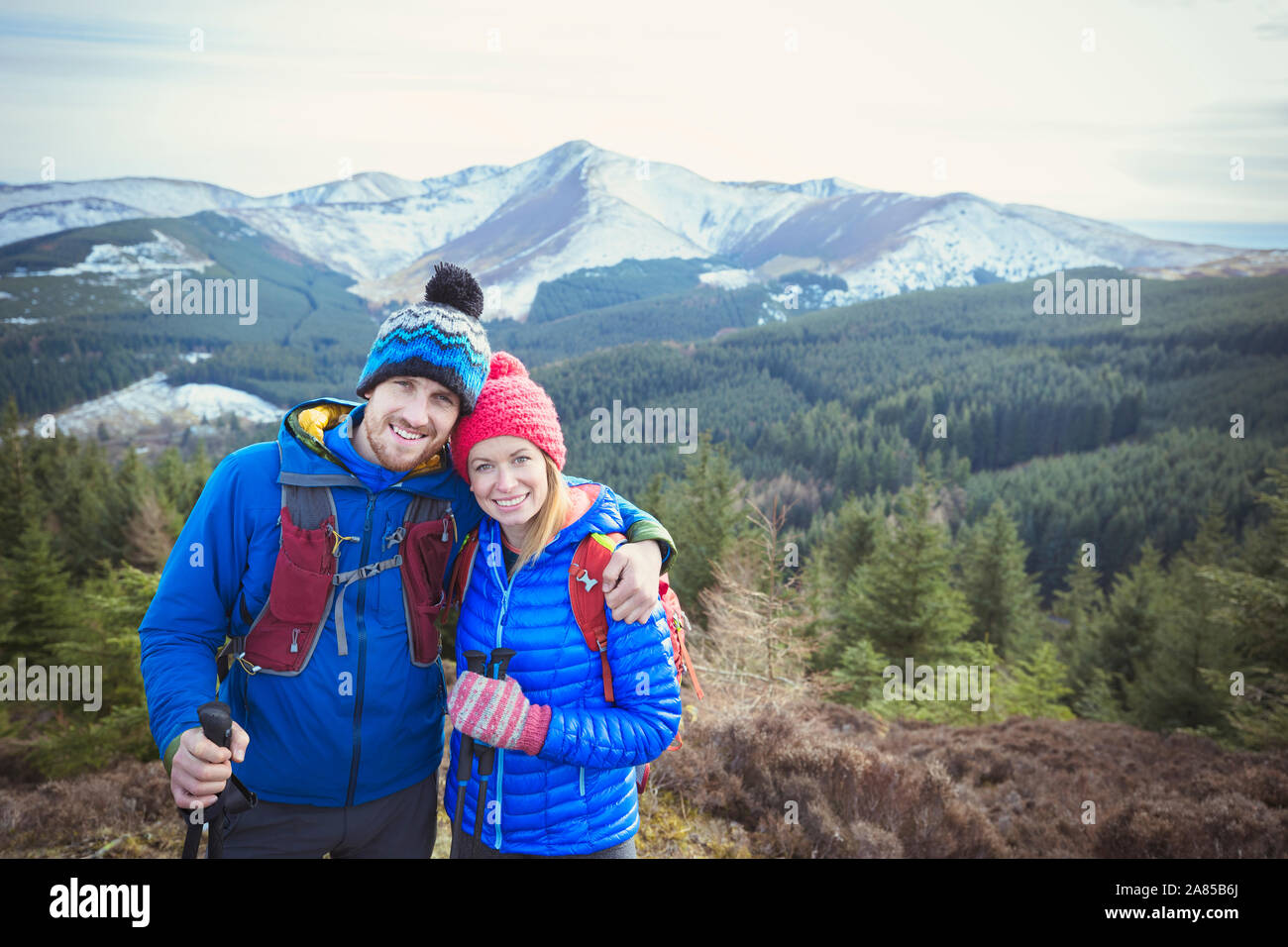 Ritratto felice coppia trekking panoramico con vista sulle montagne in background, Lake District, REGNO UNITO Foto Stock