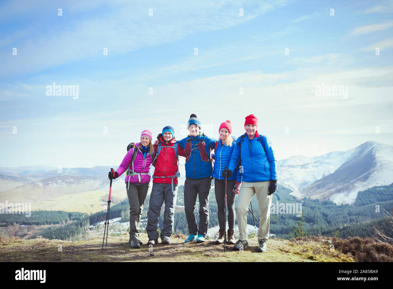 Ritratto di famiglia felice escursionismo su soleggiate cima, Lake District, REGNO UNITO Foto Stock