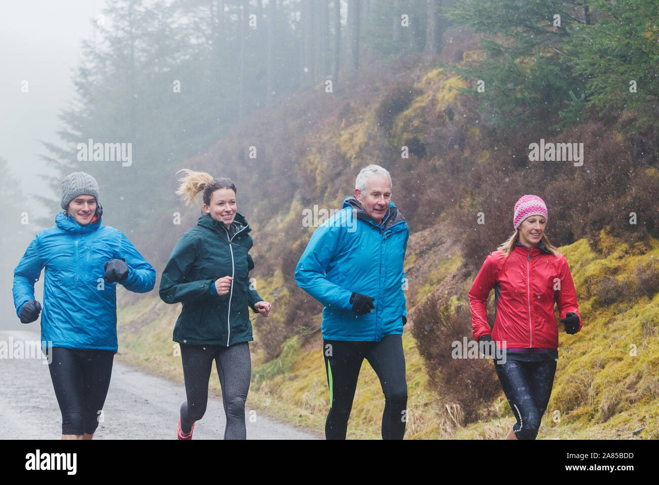 Famiglia di jogging sul sentiero nel bosco di pioggia Foto Stock