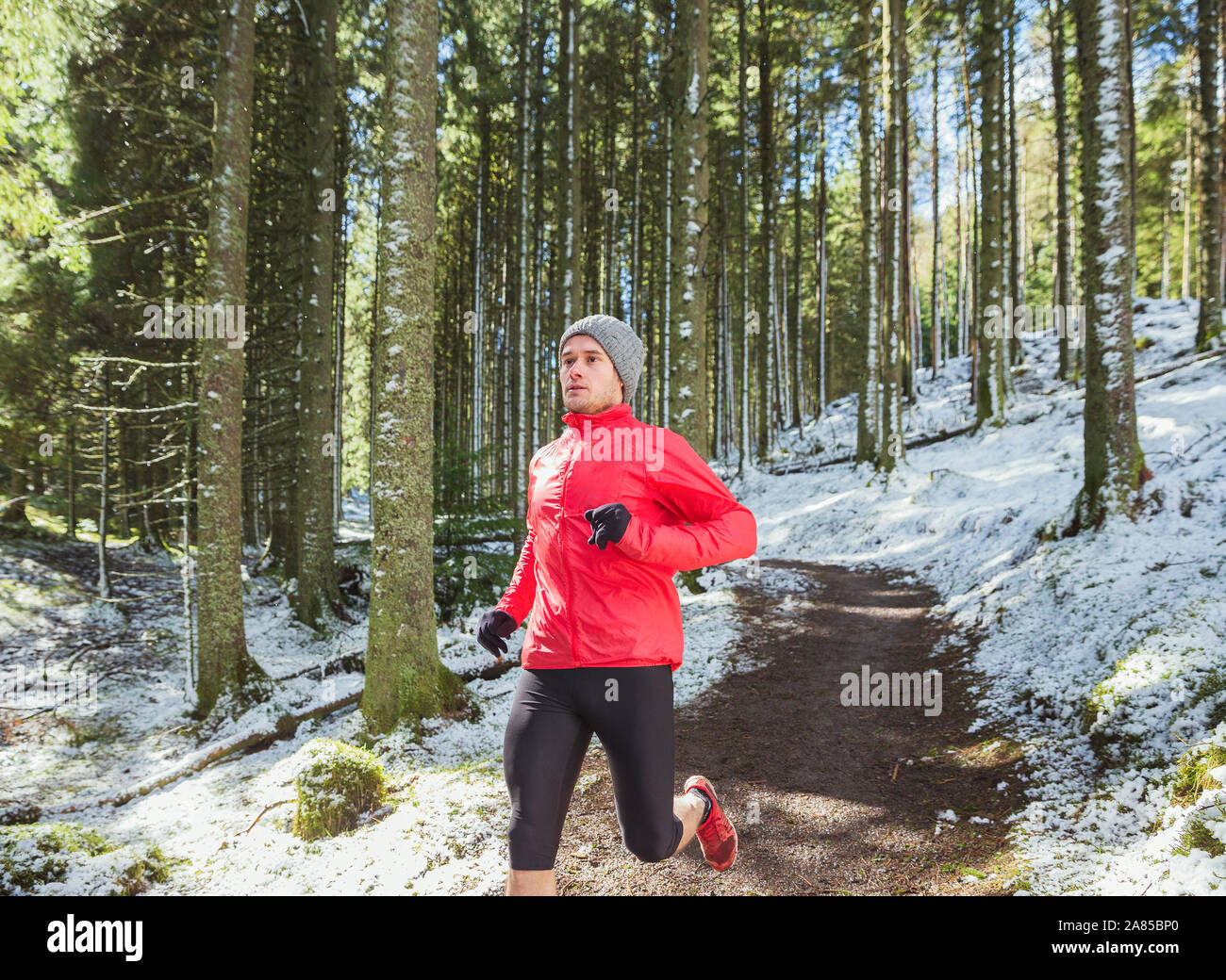 Uomo di jogging sul sentiero in nevoso, boschi remoti Foto Stock